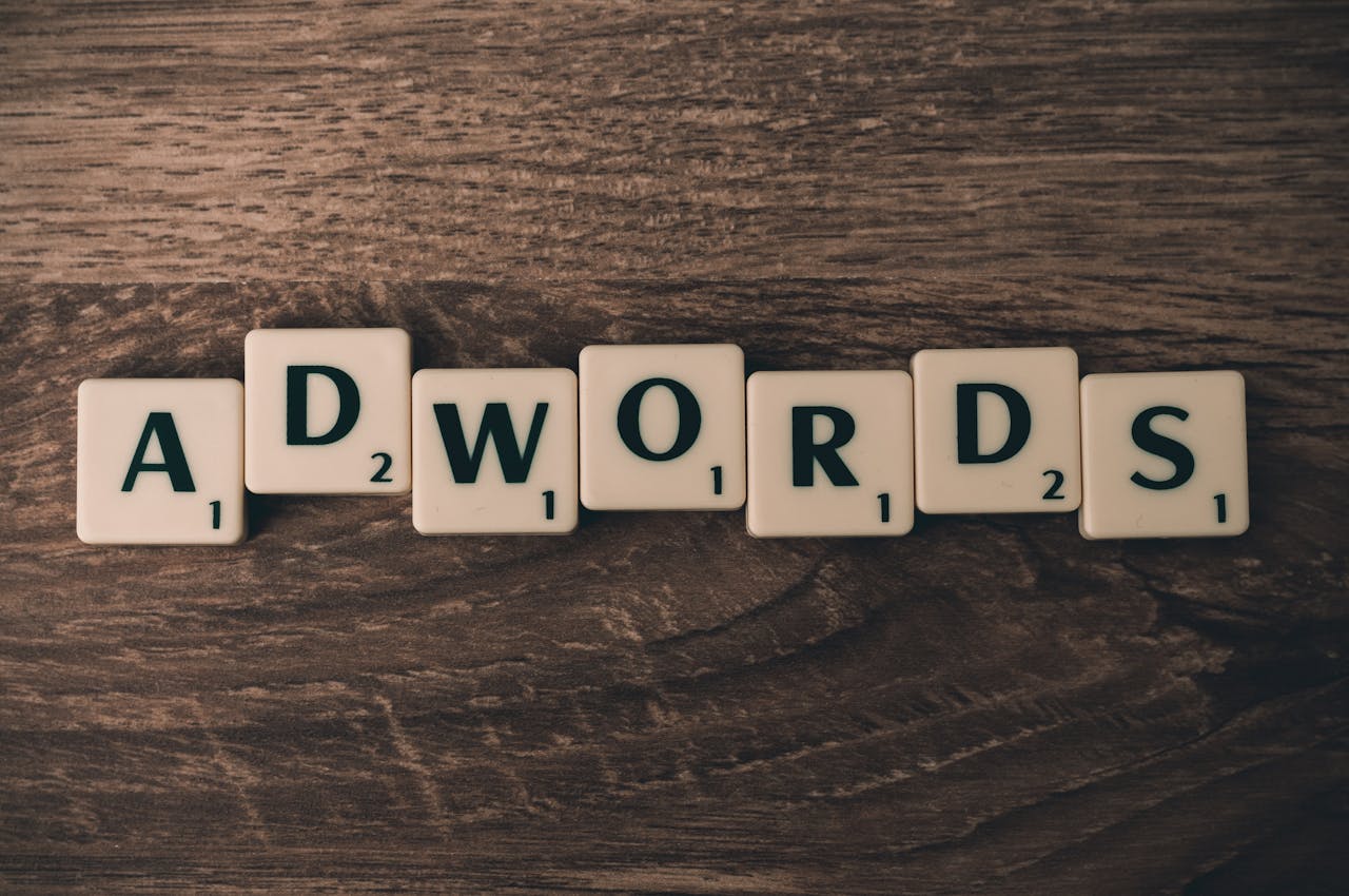 services-04 Scrabble tiles spelling 'AdWords' on a wooden surface, symbolizing digital marketing concepts.